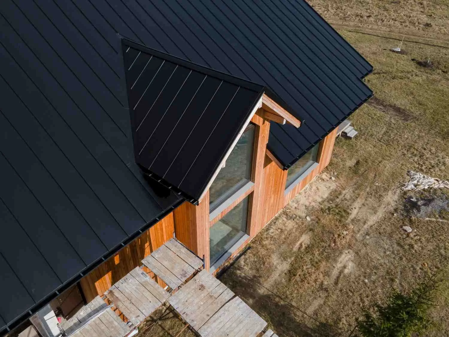 Finished dark metal roof with a dormer on a timber house, seen from above